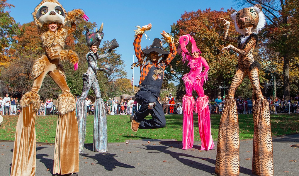 Parade de costumes avec des échassiers et des marionnettes thématiques Halloween